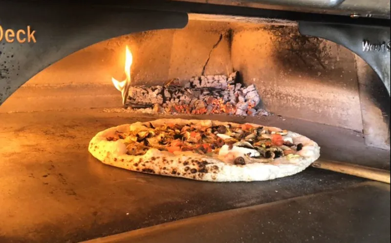 Pizza cooking in the wood-fired oven at Phillies